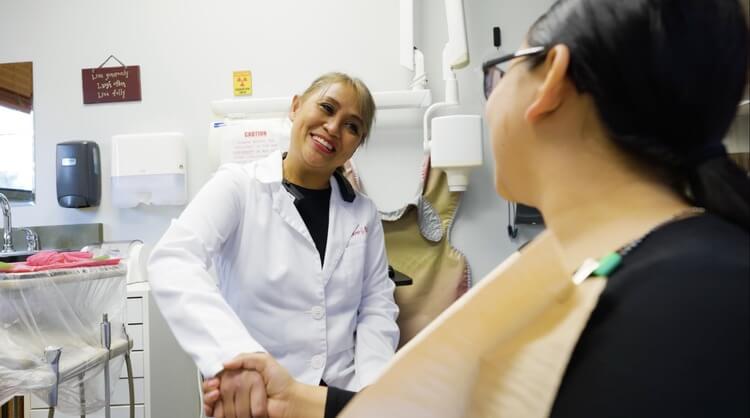 Dr. Mylene Reinicke shaking hands with a patient in colorado springs